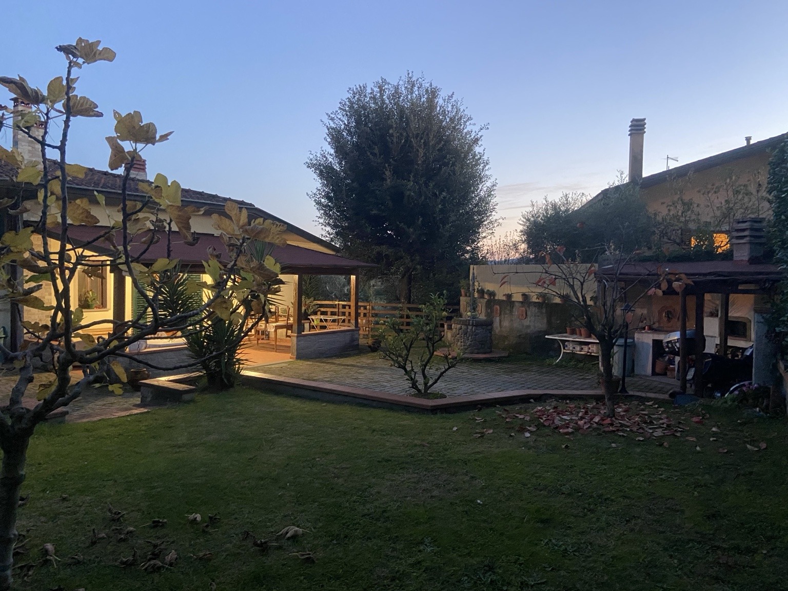 Portico illuminato e area barbecue al tramonto